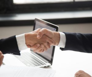 Businessman handshaking businesswoman as concept of good business deal and respect for new partner, successful partnership and great teamwork, hiring, close up view of male female hands shaking